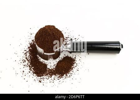 Black and silver coffee filter piled high with ground coffee angled view over white background Stock Photo