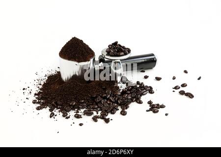 Black and silver coffee filter piled high with grounds sitting next to a tamper, beans surround the base and are stacked on top Stock Photo