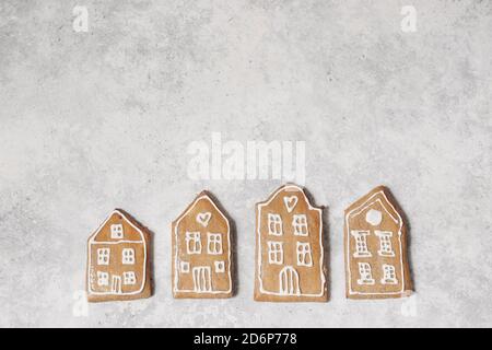 Decorative Christmas food pattern. Winter composition of old house shaped gingerbread cookies with sugar icing on grunge textured table background Stock Photo