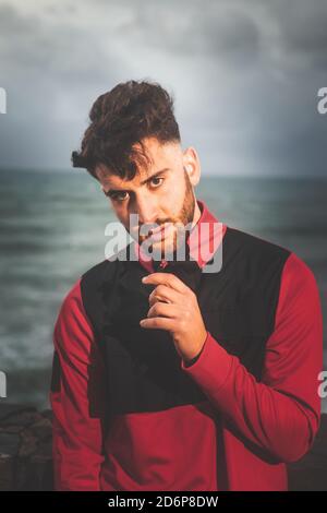 Young caucasian man posing at a sea port. Stock Photo
