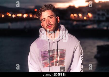 Young caucasian man posing at a sea port. Stock Photo