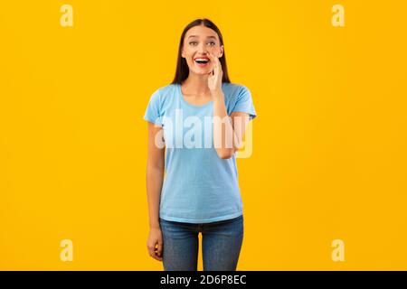 Lady holding hand near mouth, screaming at camera Stock Photo