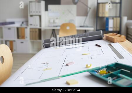 Background image of empty architects workplace with blueprints and tools on drawing table in foreground, copy space Stock Photo