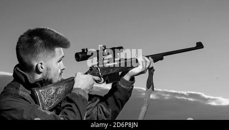 Hunting Gear - Hunting Supplies and Equipment. Hunter with shotgun gun on hunt. Hunter with Powerful Rifle with Scope Spotting Animals. Stock Photo