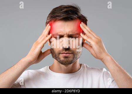Man suffering from headache, touching his temples Stock Photo