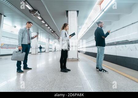 various subway passengers waiting for the arrival of the train . Stock Photo