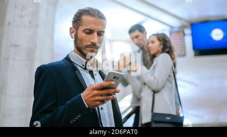 business man reading an SMS while standing on the stairs in the subway . Stock Photo