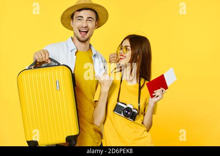 Happy man with a suitcase and women with a camera go on a trip  Stock Photo