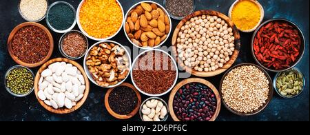Superfoods, legumes, nuts, seeds and cereals selection in bowls on grey background. Superfood as chia, spirulina, beans, goji berries, quinoa, turmeri Stock Photo