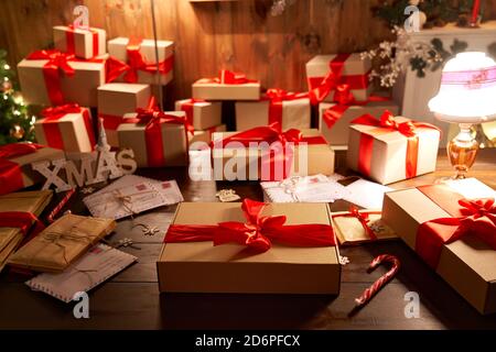 Wrapped Christmas gift box on decorated xmas table in cozy Santa workshop. Stock Photo