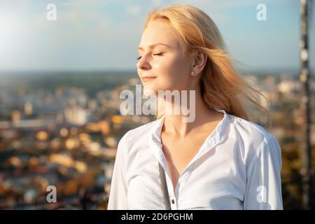 Portrait of beautiful blonde woman tourist looking on old city streets. Stock Photo