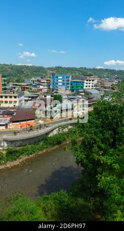 Panoramic view of the city of Tena between green trees and the river with mountains in the background in the Ecuadorian Amazon
