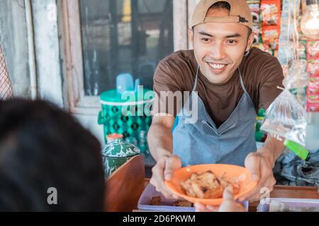 close up young man seller the cart shop smiles when serving customers at the cart stall Stock Photo
