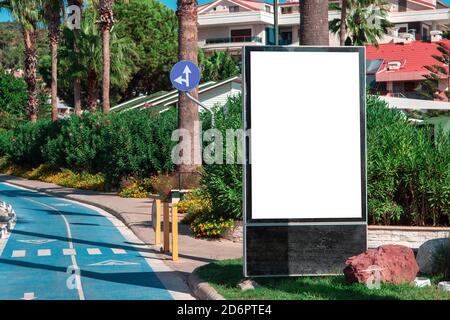 mockup of Billboard in a resort town. Empty billboard with copy space. Blank mock up of vertical street ad billboard. Advertising space under the post Stock Photo