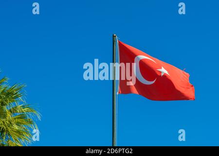 Flag of Turkey rise waving to the wind with sky in the background. Waving national flag of Turkey. Travel, tourism. Stock Photo