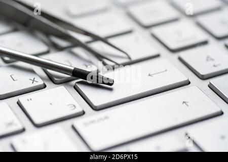 Laptop repair, screwdrivers close-up on a gray keyboard. Computer service Stock Photo