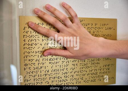 Woman reading braille text on a braille plate Stock Photo