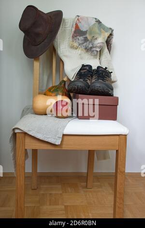 Hat, scarf,sweater, shoes and organic pumpkin on wooden chair Stock Photo