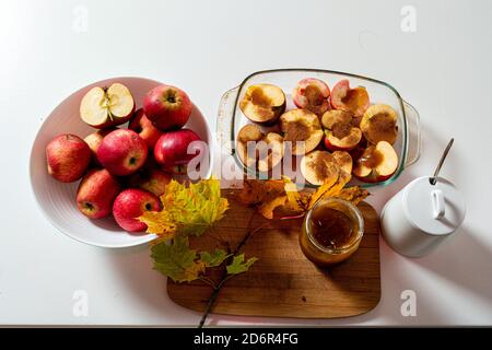 fried apples with cinnamon and honey decorated with colorful autumn leaves, homemade desert concept Stock Photo