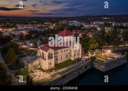 Tata, Hungary - Aerial view of the beautiful illuminated Castle of Tata by the Old Lake (Öreg-to) at dusk with colorful clouds and sky on a summer eve Stock Photo