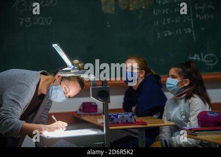 Kiel, Germany. 19th Oct, 2020. Teacher Sabine Langenbach writes something for her students on an overhead projector during a lesson after the autumn holidays with a sixth grade class at the Max-Planck-Schule-Kiel. Credit: Gregor Fischer/dpa/Alamy Live News Stock Photo