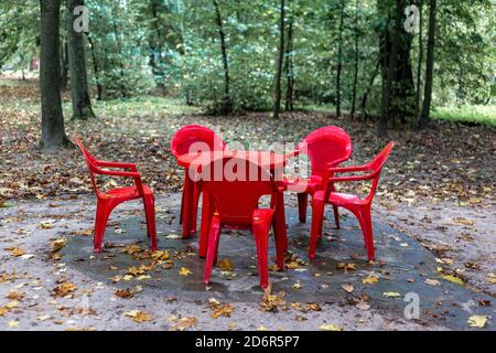 Red plastic chairs and table in the park Stock Photo