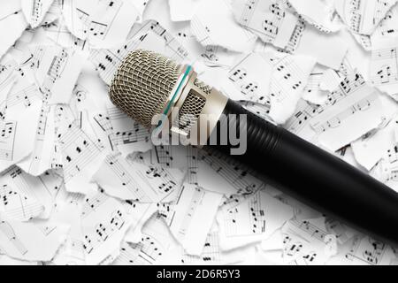 Microphone on a blurred background from pieces of paper with notes. Stock Photo