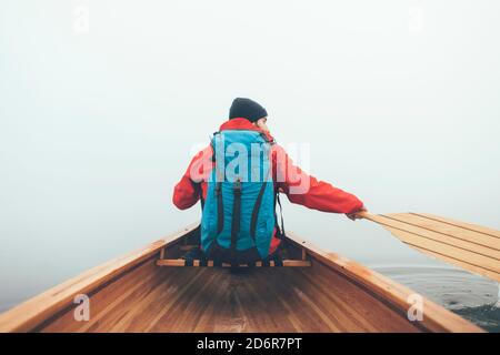 Raer view of the canoeist paddling on the hazy lake Stock Photo