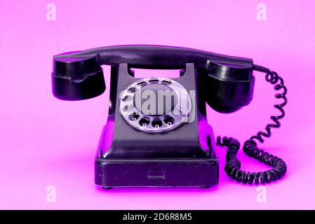 A vintage landline telephone on a colorful background. Stock Photo