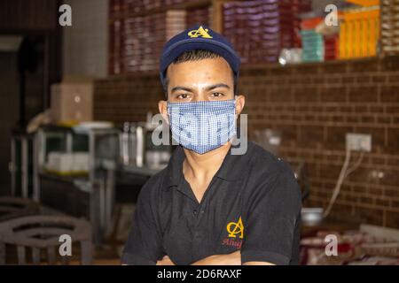 Dehradun, Uttarakhand/India-October 14 2020:A waiter in a restaurant wearing face mask in Corona pandemic in india. . High quality photo Stock Photo