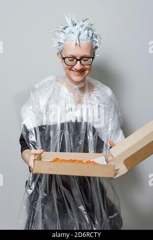 woman with a box of pizza in the process of dyeing her hair Stock Photo