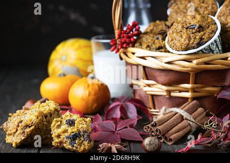 Homemade pumpkin spicy muffins with nuts and raisin, pumpkins and spices on rustic background. Autumn and winter baking. Stock Photo