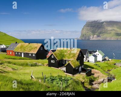 Village Mikladalur, on the Island  Kalsoy, in  background the island Kunoy. Nordoyggjar (Northern Isles) in the Faroe Islands, an archipelago in the n Stock Photo