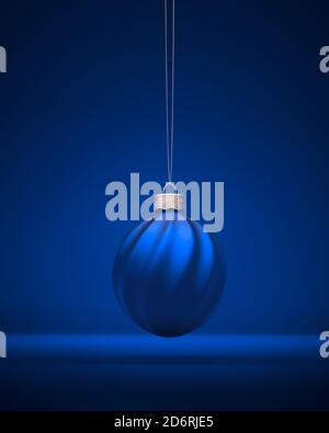 Royal blue Christmas ball hanging on silver string. Christmas ornament decorated with twisted stripes. Christmas decoration, festive atmosphere concep Stock Photo