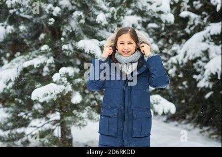 portrait of a beautiful caucasian girl on a background of snow-covered Christmas trees. Stock Photo