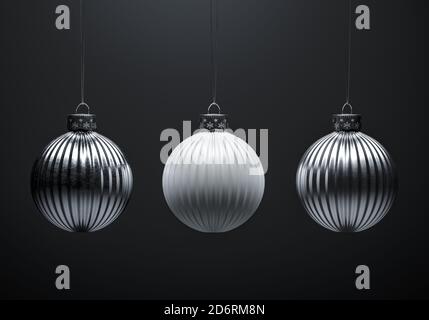 Three vertically striped Christmas balls on dark gray background. White and silver metal textured baubles. Christmas decoration, festive atmosphere co Stock Photo