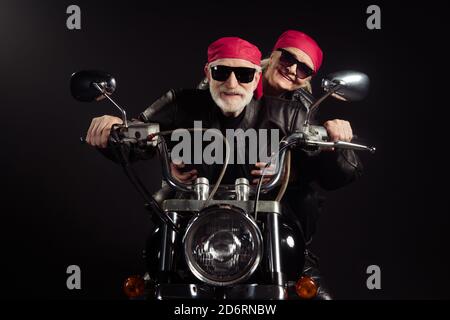 Photo of two cool old bikers grey hair man lady couple drive vintage chopper traveling together feel young wear rocker leather jacket outfit bandana Stock Photo