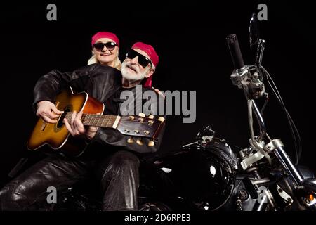 Photo of aged bikers man lady couple sit chopper moto rock bike festival meeting play sing guitar remember youth times wear trendy rocker leather Stock Photo