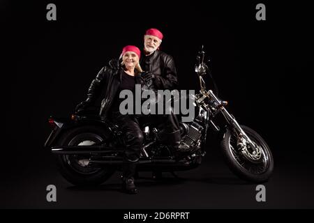Photo of aged bikers grey haired man lady soulmates couple drive vintage chopper feel young metal music festival wear rocker leather jacket pants Stock Photo