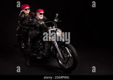 Full length photo of aged bikers grey haired man lady couple drive moto traveling rock festival for pensioners wear rocker leather jacket pants Stock Photo