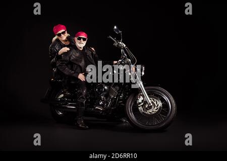 Photo of aged bikers grey haired man lady soulmates married couple drive vintage chopper to stars together feel young wear rocker leather jacket pants Stock Photo