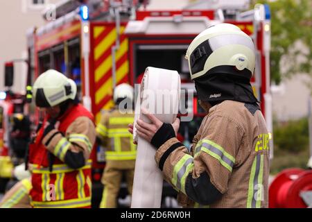 Freital, Germany. 12th Oct, 2020. A fireman from behind holds a rolled up water hose in his hand. Credit: Tino Plunert/dpa-Zentralbild/ZB/dpa/Alamy Live News Stock Photo