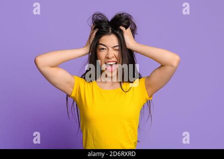 Mad Mood. Crazy Asian Woman Touching Tousled Hair And Winking At Camera Stock Photo