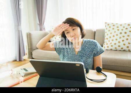 Asian woman aged 30-35 years using tablet, watching lesson Sign language online course communicate by conference video call from home, e-learning educ Stock Photo