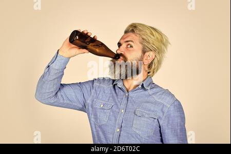 mature man holding glass bottle of beer. drunk hipster male craft bottled beer. happy man hold full glass bottle in hand. male holding bottle of beer. hipster rest in pub. Sports lover cheer up. Stock Photo