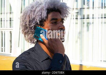 Afro black man talking on the phone in the city. Afro man concept. Making a phone call. Stock Photo
