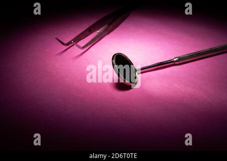 From above of various dental instruments arranged in row on pink table in clinic Stock Photo