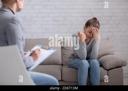 Psychological help concept. Millennial woman with depression having counseling session with therapist at office Stock Photo