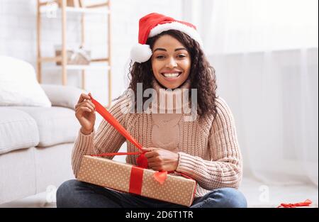 Black Woman Opening Present Box At Home Stock Photo