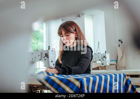 Seamstress working on the sewing machine Stock Photo